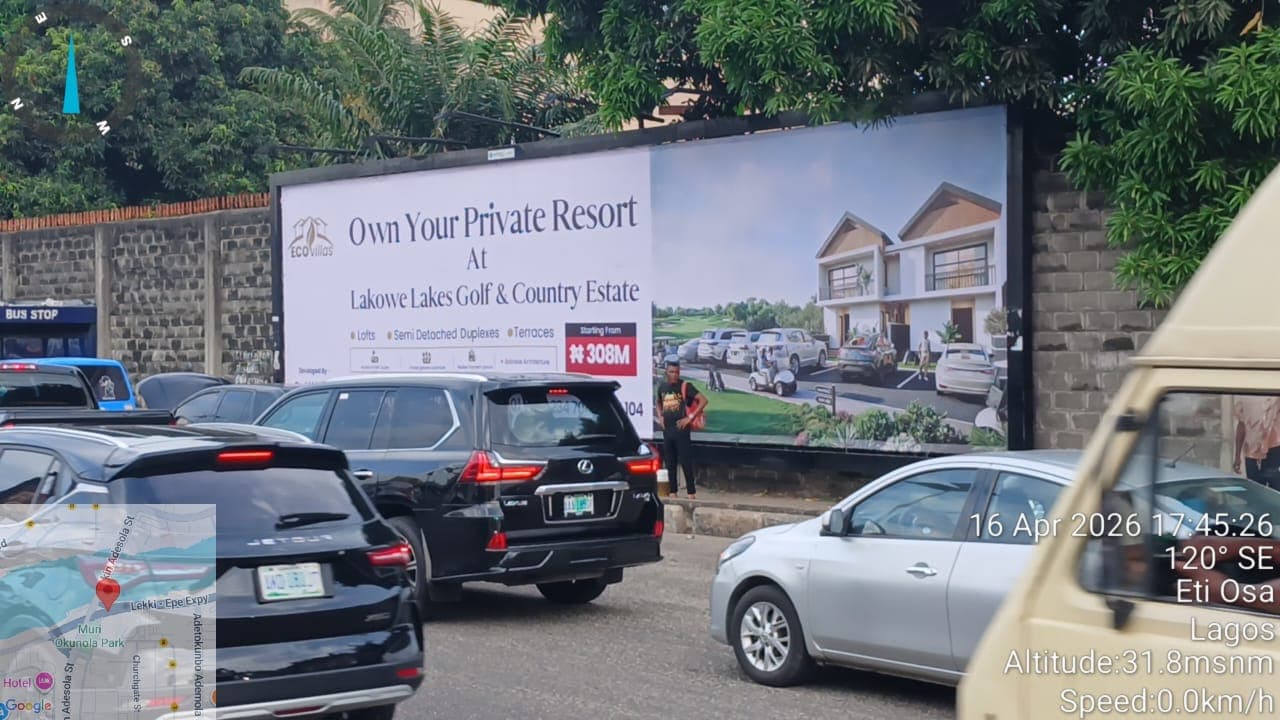 EcoVillas billboard advertising homes at Lakowe Lakes Golf and Country Estate, seen across queued traffic.