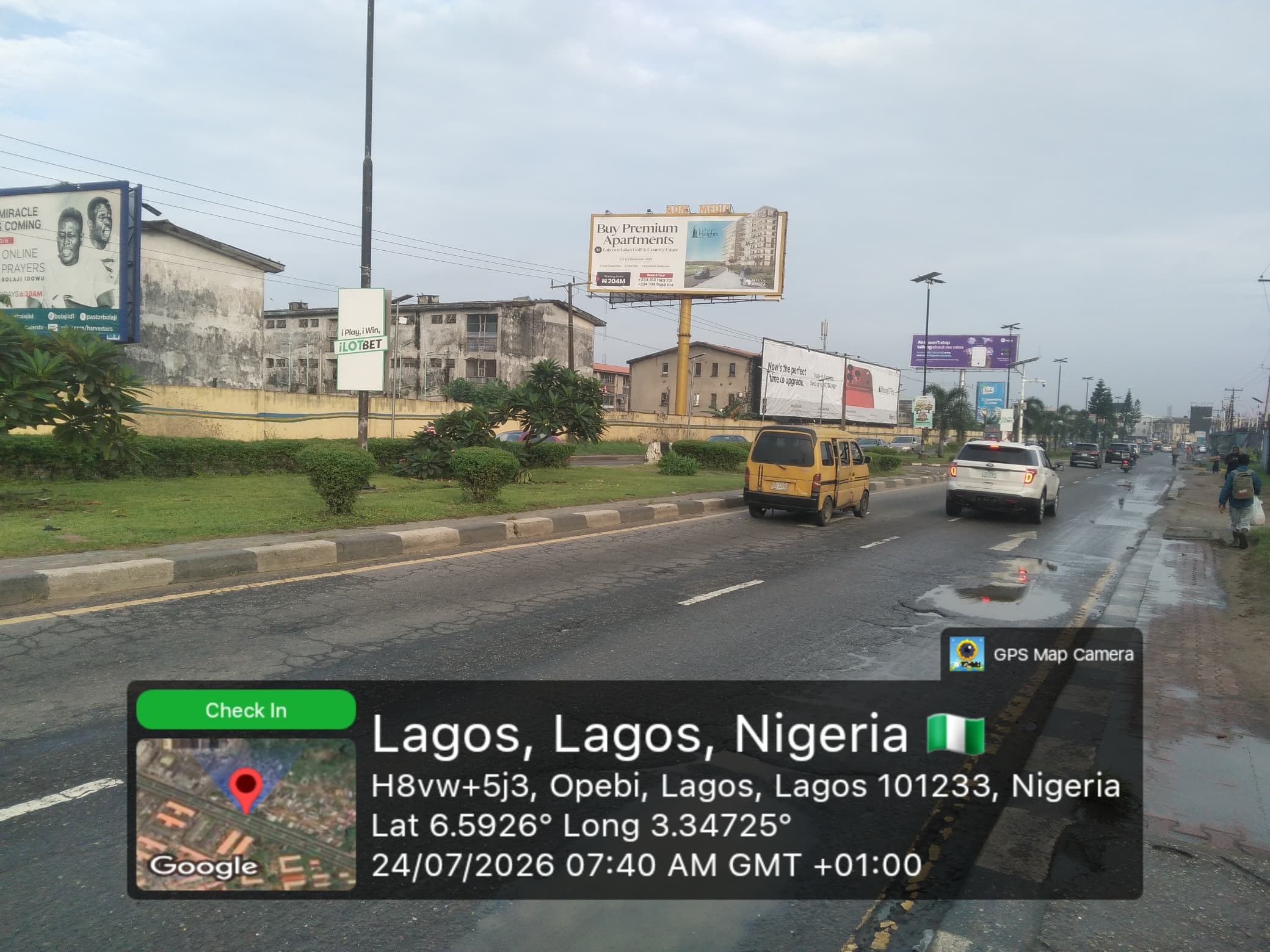 A run of billboards along the Opebi corridor in Lagos at first light, several sites in one view.